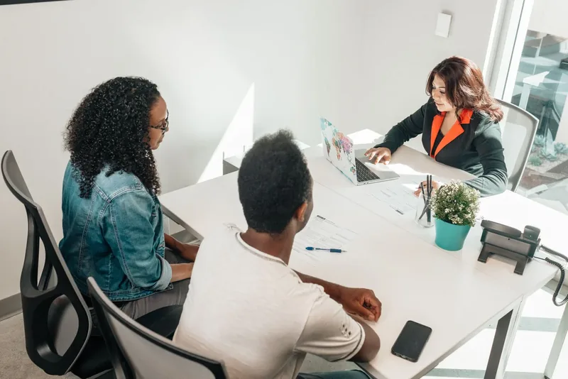 A small team discussing a plan around a meeting table