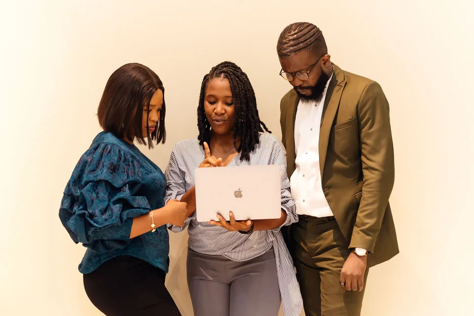 Colleagues reviewing a process on a laptop