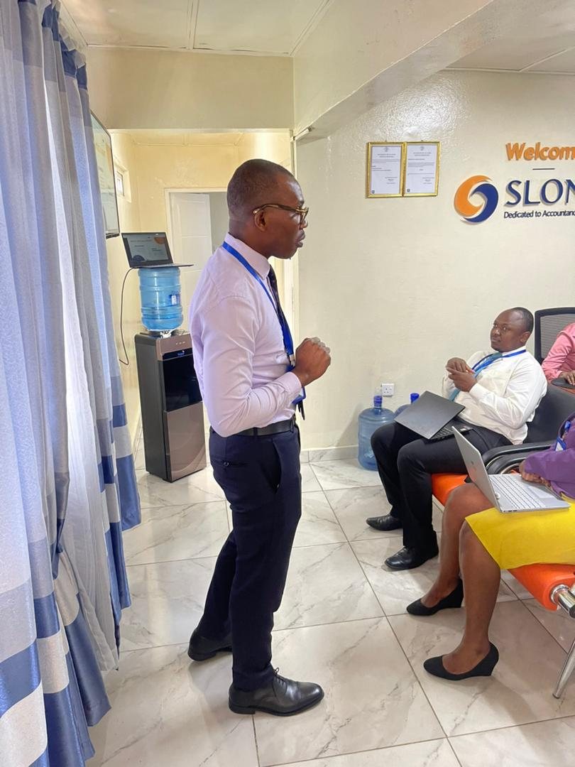 A SLONEC adviser speaking with clients at the SLONEC office in Freetown