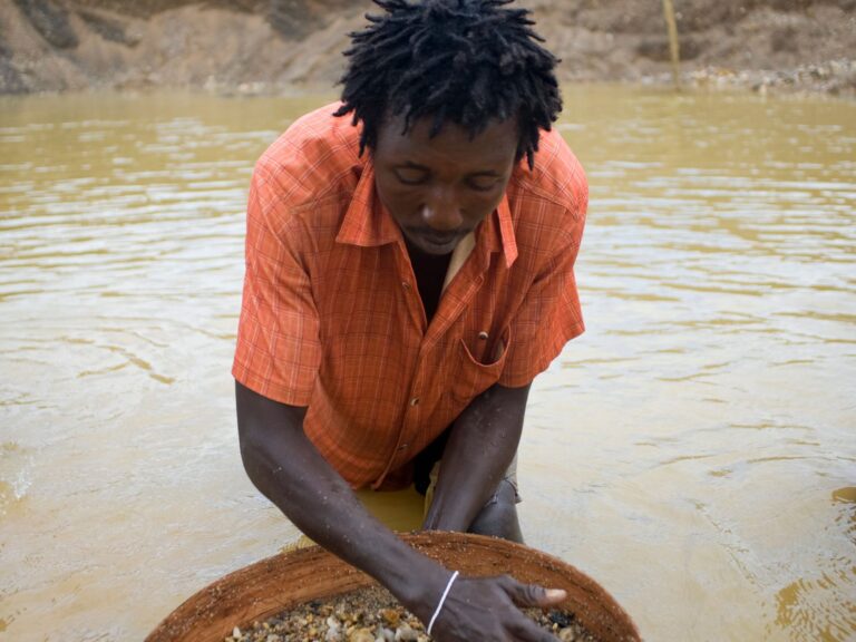 A miner panning gravel for diamonds in Sierra Leone