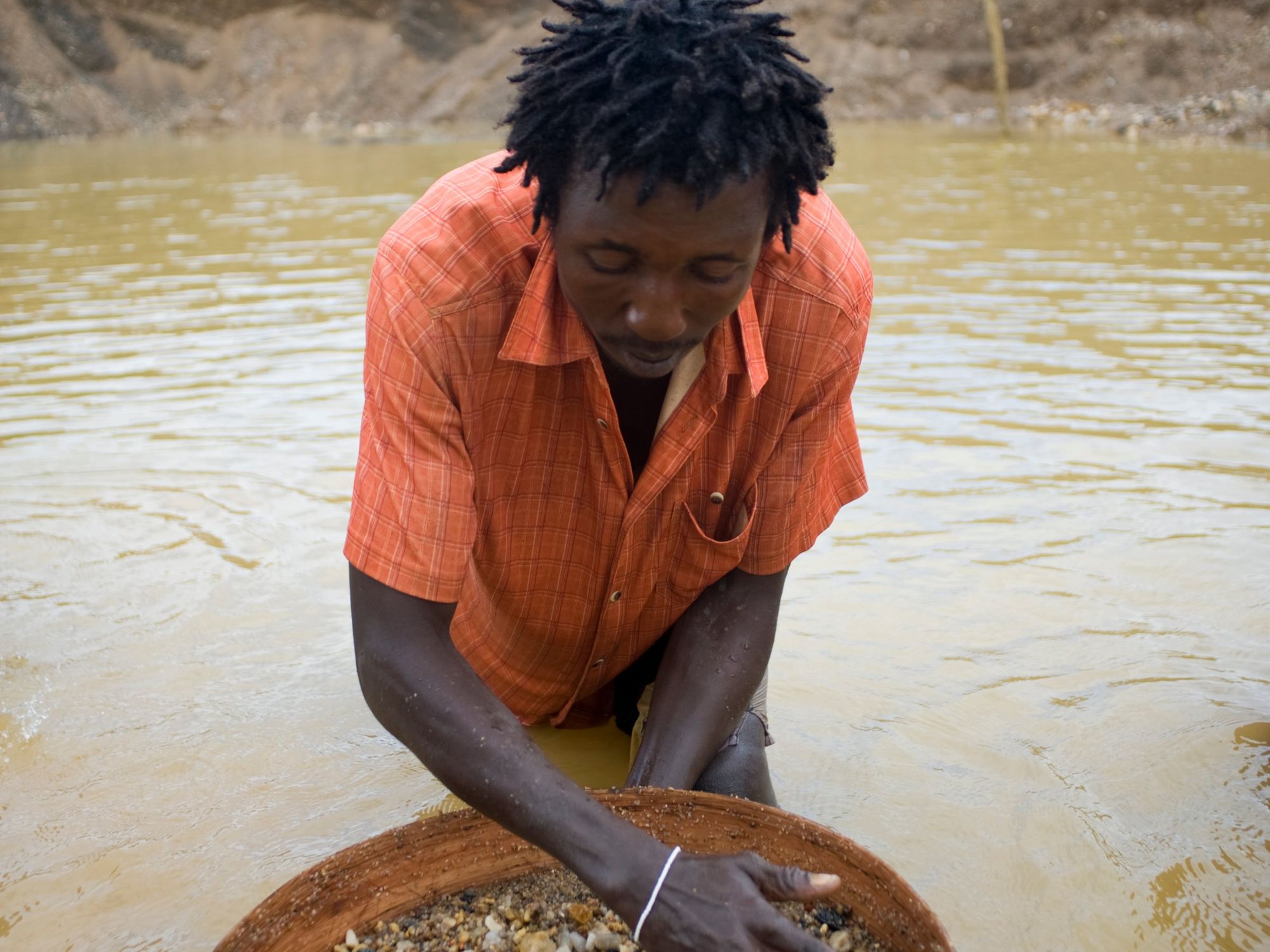 A miner panning gravel for diamonds in Sierra Leone