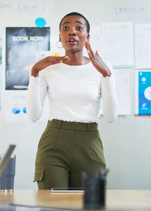 Shot of a young businesswoman delivering a presentation to colleagues in a modern office.